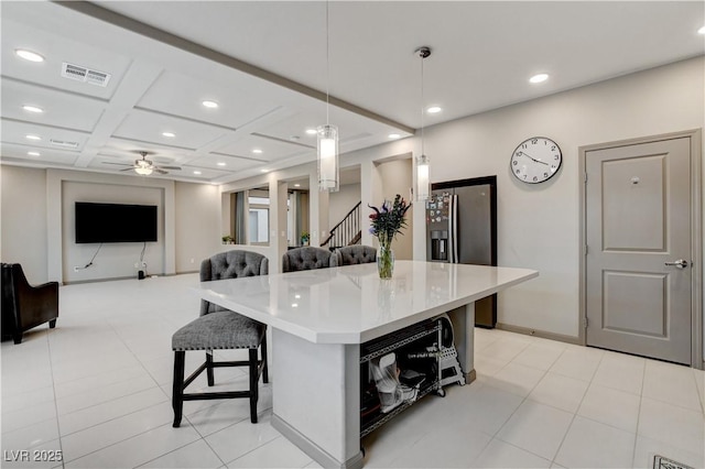 kitchen with decorative light fixtures, a breakfast bar area, recessed lighting, light countertops, and visible vents