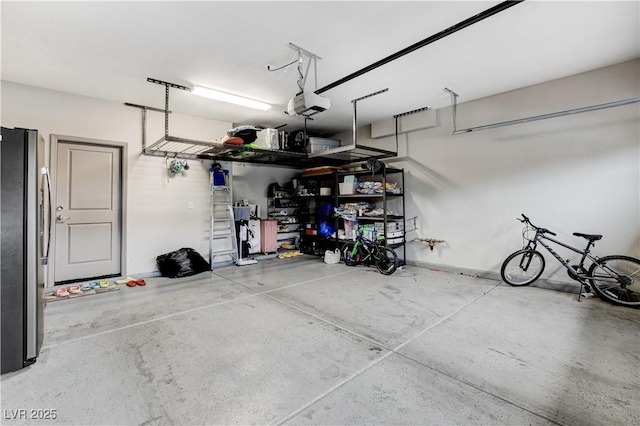 garage featuring a garage door opener and freestanding refrigerator