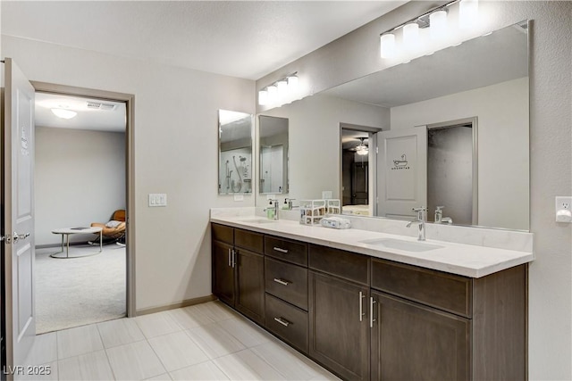 bathroom featuring double vanity, a sink, visible vents, and baseboards