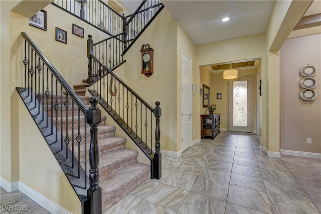 entrance foyer with crown molding and baseboards