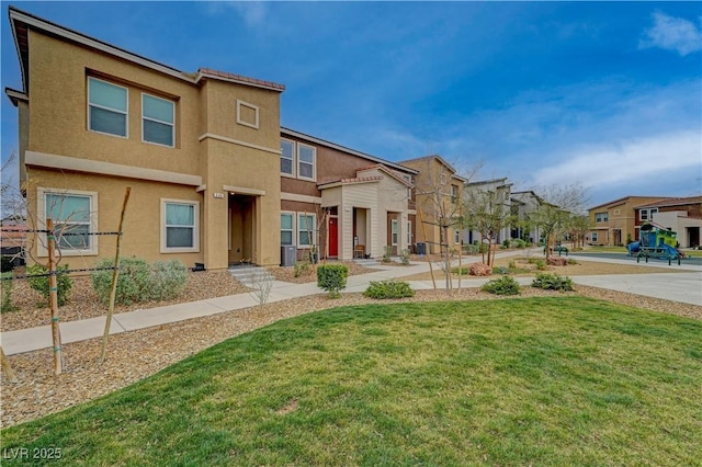 view of front of property featuring a front yard, a residential view, and stucco siding