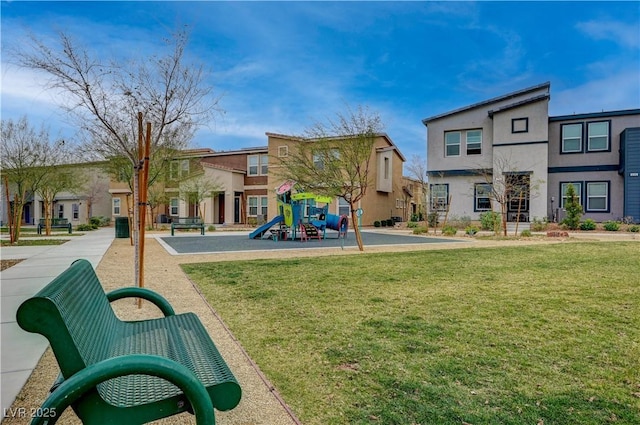 communal playground featuring a residential view and a lawn