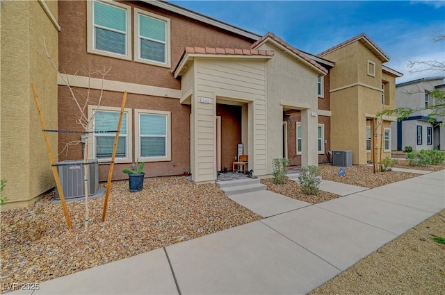 view of property featuring stucco siding and central AC unit