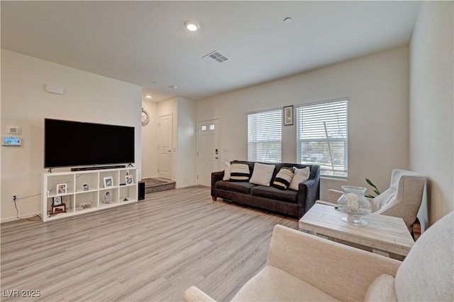 living area with recessed lighting, visible vents, baseboards, and wood finished floors