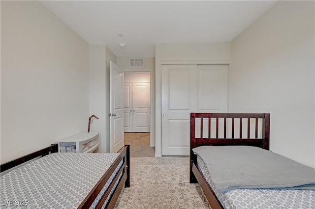 bedroom featuring carpet, visible vents, and a closet