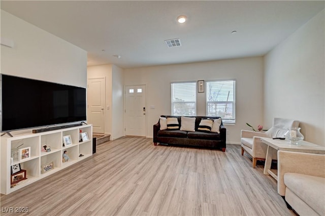 living area featuring light wood finished floors, visible vents, and baseboards