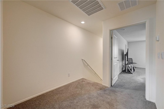 corridor with carpet, visible vents, and an upstairs landing