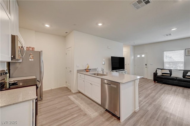 kitchen featuring white cabinets, visible vents, stainless steel appliances, and a sink