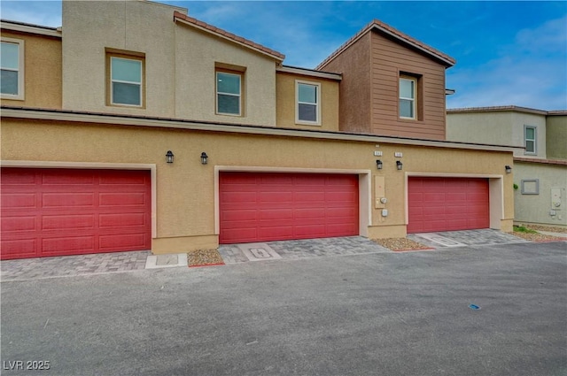 multi unit property with a garage and stucco siding