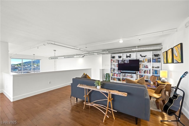 living area with baseboards and wood finished floors