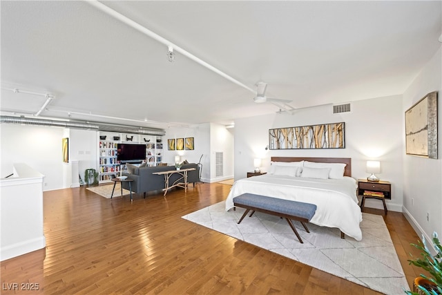 bedroom with light wood finished floors, visible vents, and baseboards