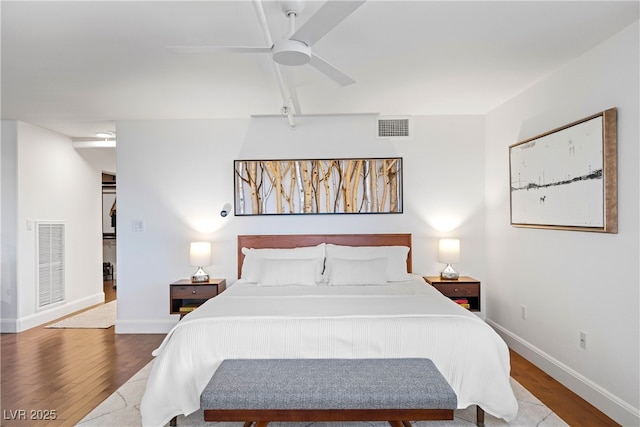 bedroom featuring baseboards, visible vents, and wood finished floors