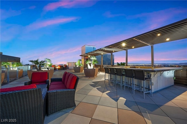 patio terrace at dusk with outdoor dry bar and an outdoor living space