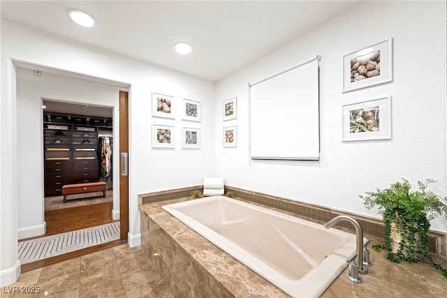 full bathroom with baseboards, a garden tub, and recessed lighting