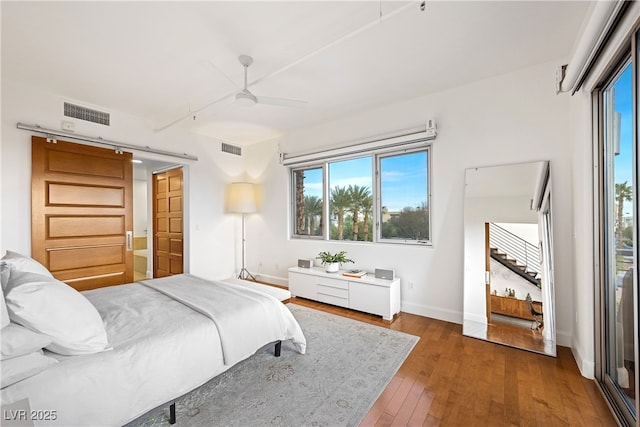 bedroom with wood-type flooring, visible vents, ceiling fan, and baseboards