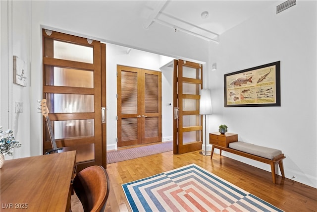 interior space featuring light wood finished floors, french doors, visible vents, and baseboards