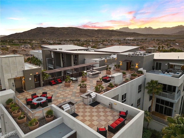 back of property at dusk with a patio, an outdoor fire pit, and a mountain view