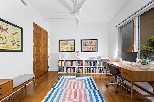 home office featuring visible vents, ceiling fan, and wood finished floors