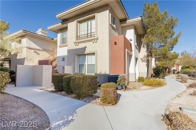 view of side of home with central AC unit and stucco siding