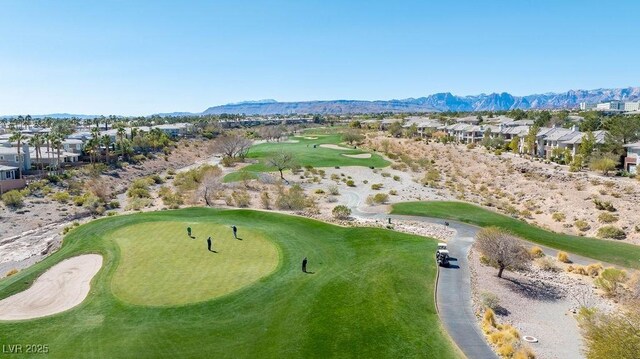 drone / aerial view with view of golf course, a residential view, and a mountain view