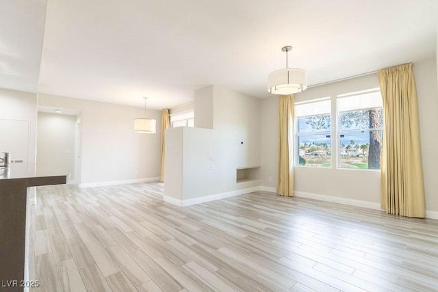 empty room featuring light wood-type flooring and baseboards