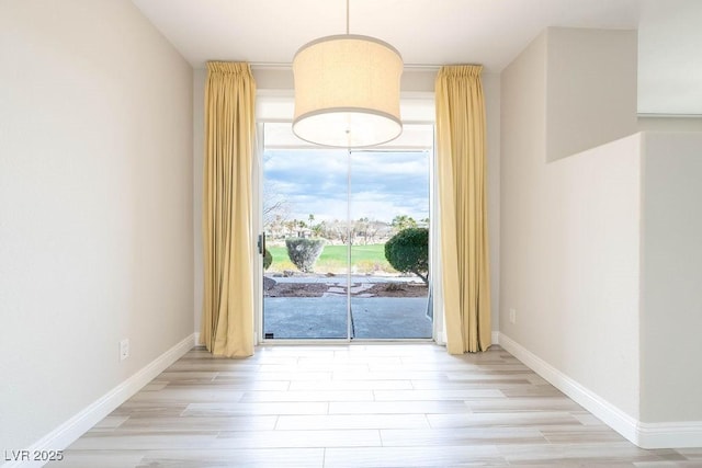 interior space featuring baseboards and wood finished floors