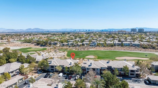 drone / aerial view with a mountain view, golf course view, and a residential view