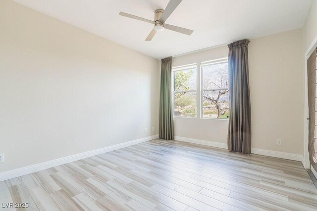 empty room with light wood-style floors, a ceiling fan, and baseboards