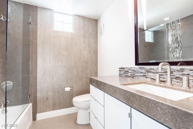 bathroom with tasteful backsplash, baseboards, toilet, tile patterned floors, and vanity