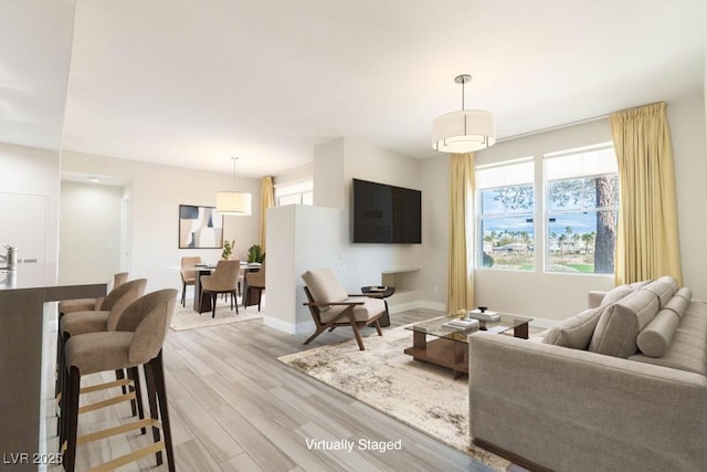 living area with light wood-type flooring and baseboards