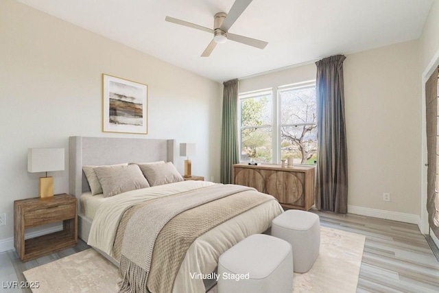 bedroom with a ceiling fan, light wood-style floors, and baseboards