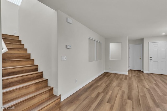 interior space with baseboards, recessed lighting, stairs, and light wood-style floors