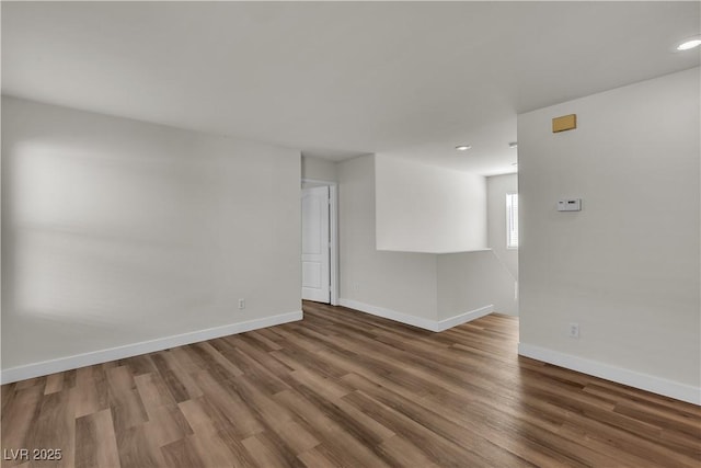 empty room with baseboards, recessed lighting, and wood finished floors