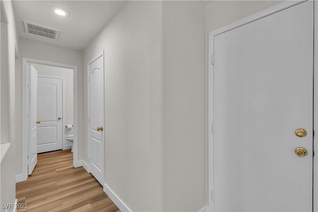 corridor with recessed lighting, baseboards, visible vents, and light wood-style floors