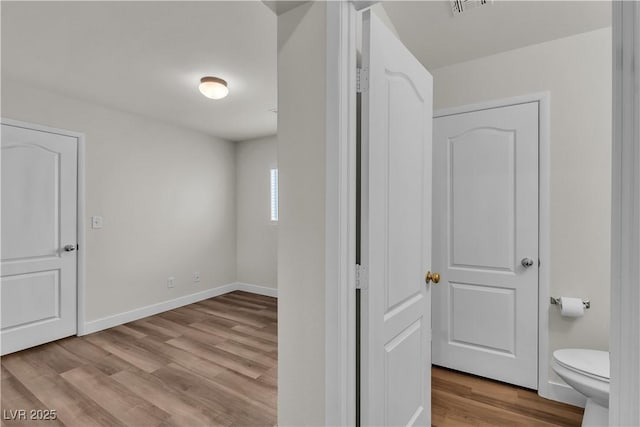 interior space with baseboards and wood finished floors