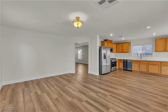 kitchen featuring visible vents, light countertops, light wood finished floors, and stainless steel appliances