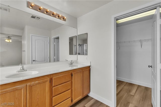 bathroom featuring visible vents, a sink, and wood finished floors