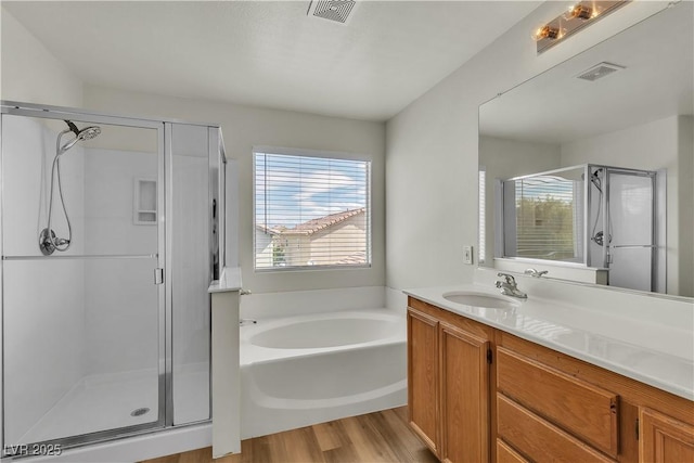 full bath featuring vanity, a stall shower, a bath, and visible vents