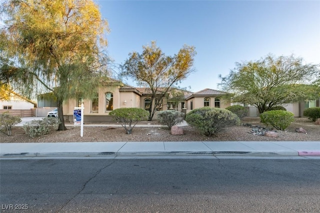 view of front of house with a tile roof and stucco siding