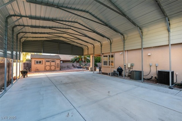 exterior space with a storage unit, fence, cooling unit, and a detached carport