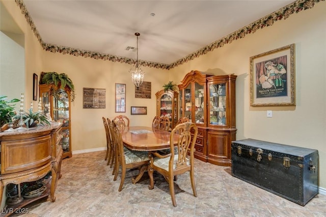 dining space featuring a chandelier, visible vents, and baseboards