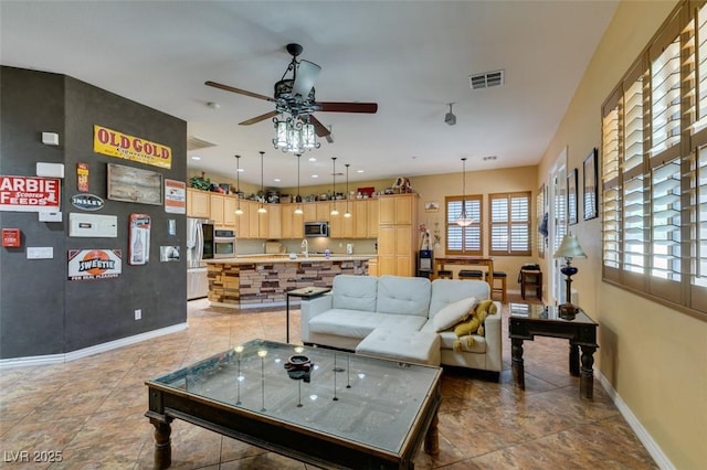 living room with ceiling fan, light tile patterned floors, visible vents, and baseboards