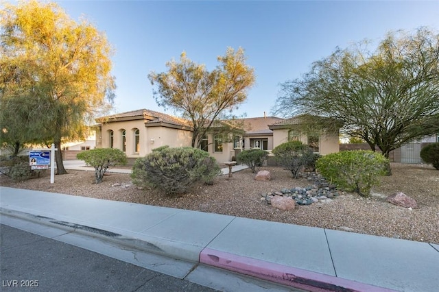 view of front of house featuring a tiled roof and stucco siding