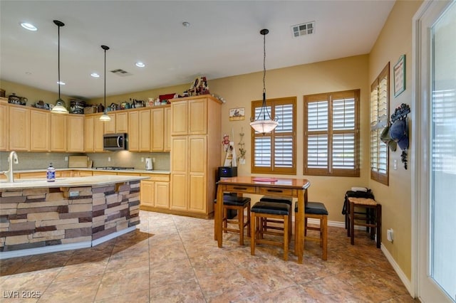 kitchen with visible vents, appliances with stainless steel finishes, tasteful backsplash, and light brown cabinetry