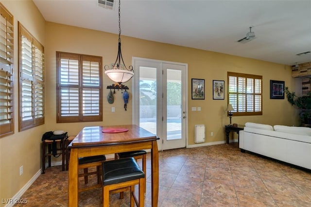 tiled dining room featuring baseboards and visible vents