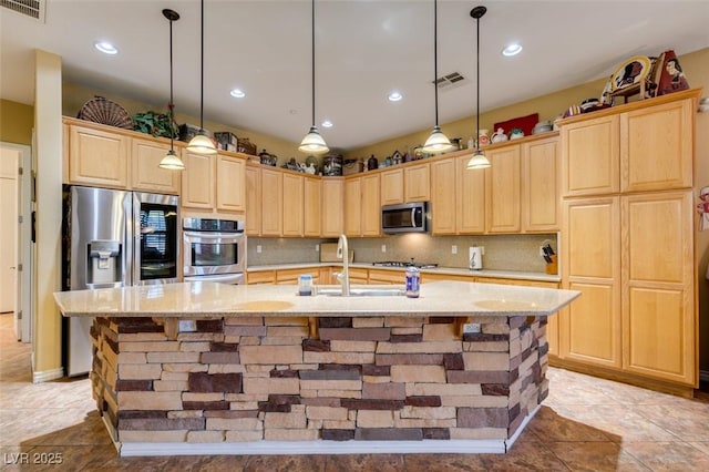 kitchen with stainless steel appliances, tasteful backsplash, a sink, and light brown cabinetry