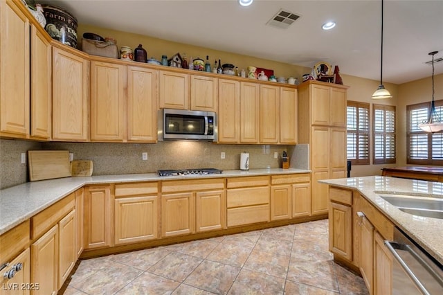 kitchen with stainless steel appliances, visible vents, backsplash, light brown cabinetry, and pendant lighting