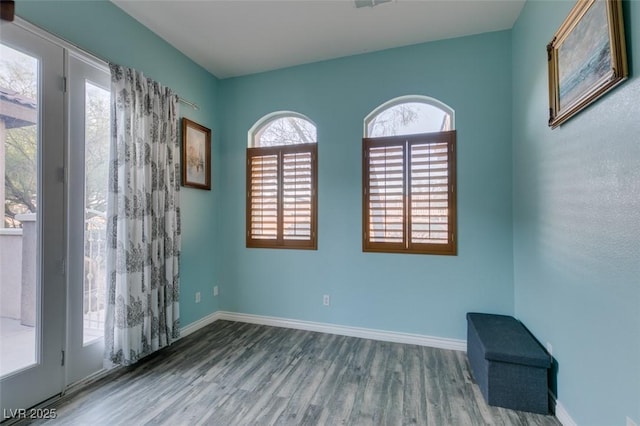 empty room featuring wood finished floors and baseboards