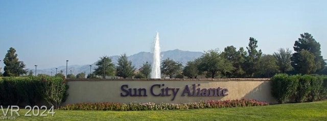 community sign with a lawn and a mountain view