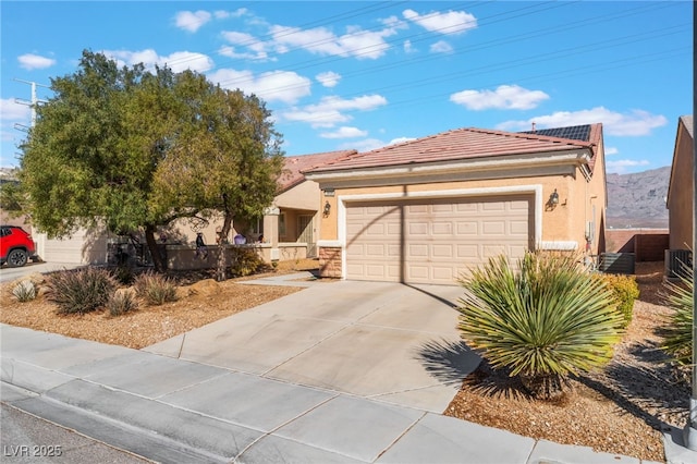 view of front of home with driveway, a tiled roof, fence, and stucco siding